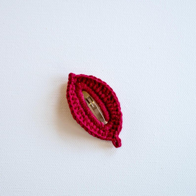 May include: A burgundy crocheted hair clip with a metal clasp.