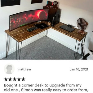 K&ouml;nnte beinhalten: Ein Ecktisch aus recyceltem Holz mit Haarnadelbeinen. Der Tisch hat einen gebogenen Monitor und einen Laptop auf der Oberfl&auml;che. Der Tisch befindet sich in einem Heimb&uuml;ro mit einem Ventilator und anderen Dekorationen.