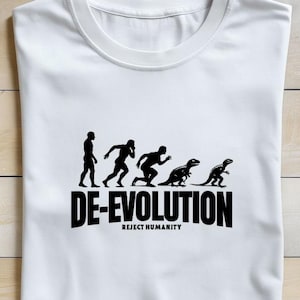 May include: White t-shirt with a black graphic depicting the evolution of a human into a dinosaur, with the text "DE-EVOLUTION" and "REJECT HUMANITY" below. The shirt is folded on a light brown wooden surface.