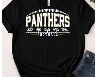 Può includere: Una t-shirt nera a maniche corte con una grafica bianca e oro raffigurante un pallone da football, la parola PANTHERS in grandi lettere stampatello, una marcatura di campo con i numeri 30, 40, 50, 40, 30 e la parola FOOTBALL.