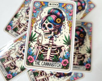 May include: A collection of stickers featuring a colorful illustration of a skeleton woman with a floral design, smoking a cigarette. The text "THE CANNABITCH" is displayed on the main sticker, surrounded by cannabis leaves and flowers. The number "420" is also visible.
