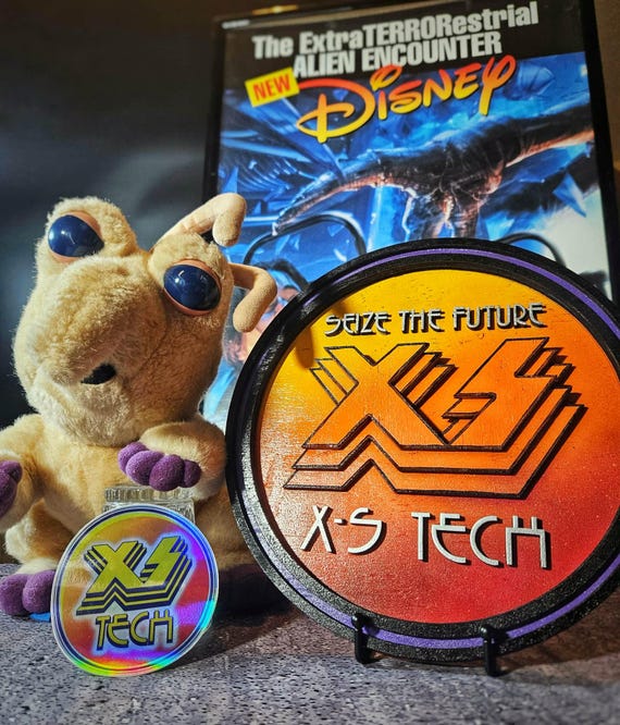 Handmade wood recreation of the cult-classic X-S Tech sign from Disney's scrapped ExtraTERRORestrial ride — hyper-specific fan art that hardcore Disney nerds will immediately recognize and lose their minds over.