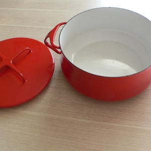 Puede incluir: Una taza de cerámica blanca con un asa negra y el texto "But First, Coffee" en negro, con una fuente de estilo manuscrito. La taza está sobre una superficie blanca.