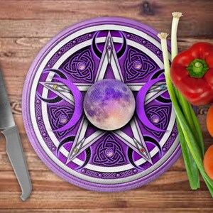 May include: A round purple and white cutting board with a pentagram design, a silver knife, and fresh vegetables. The cutting board features a central sphere and crescent moon shapes. Vegetables include red and yellow bell peppers, tomatoes, and spring onions.