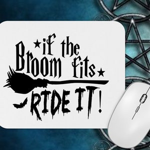 May include: A white rectangular mousepad with rounded corners. The mousepad features black text and a broom graphic that reads "If the broom fits, ride it!" A white wireless mouse is in the lower right corner.
