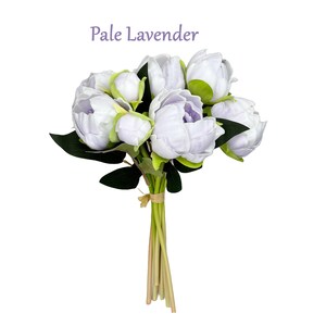 May include: A bouquet of pale lavender artificial peonies with green leaves and stems. The bouquet is tied with a brown ribbon and the text "Pale Lavender" is written above the bouquet.