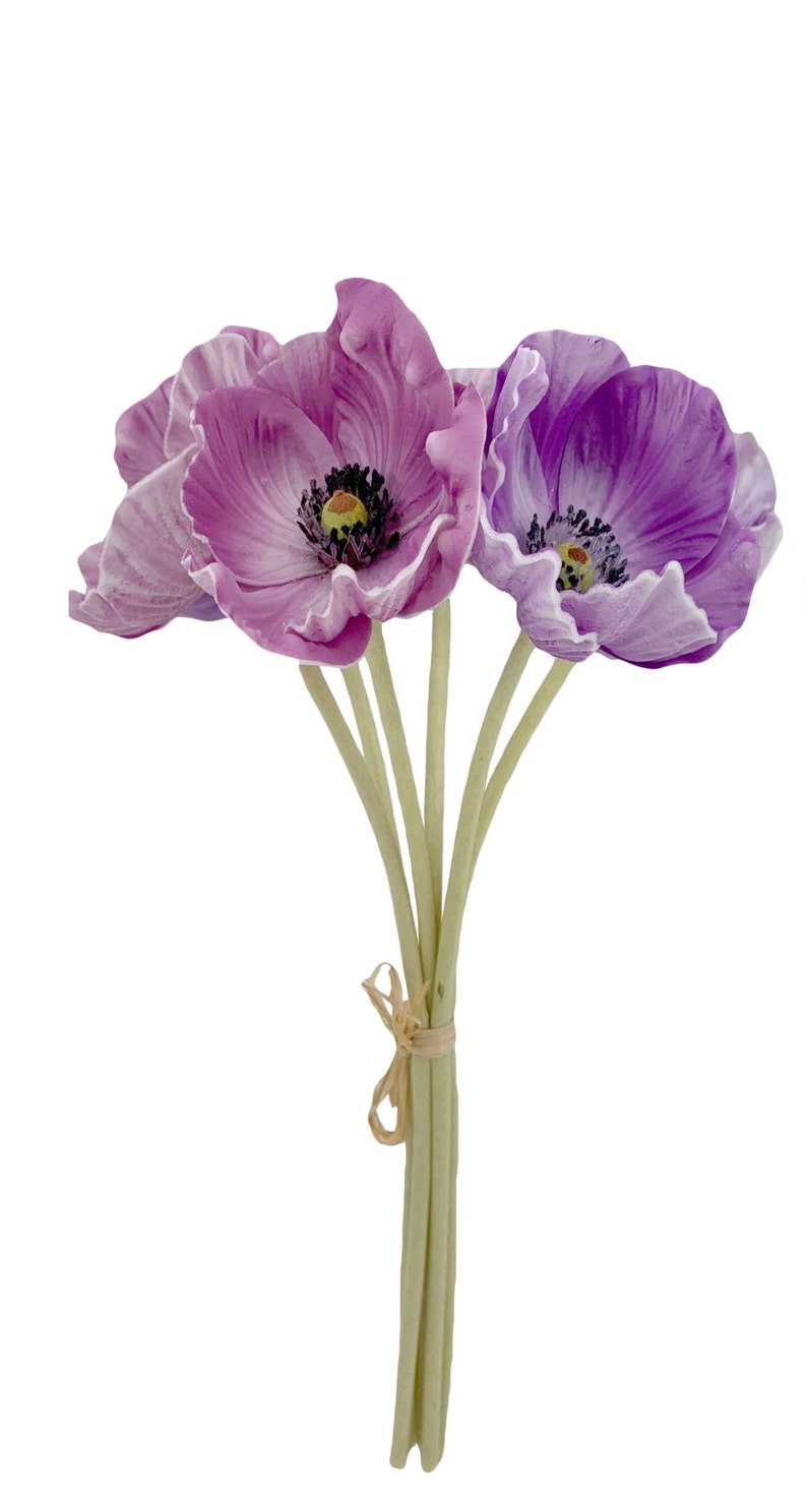 May include: A bouquet of five artificial purple poppies with green stems tied together with a brown ribbon.