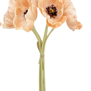 May include: A bouquet of three peach-colored artificial poppy flowers with brown centers. The stems are green and tied together with a brown ribbon.