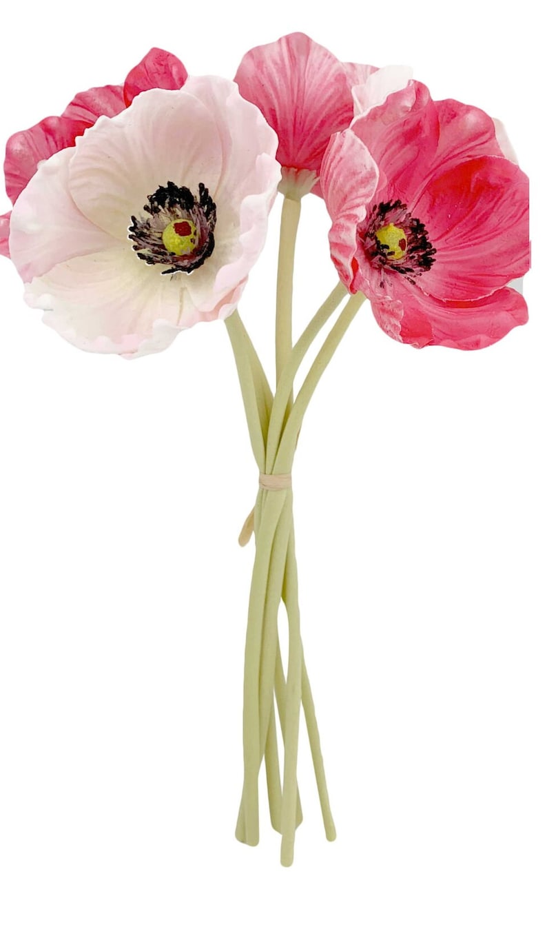 May include: A bouquet of six artificial pink and white poppy flowers with green stems tied together.