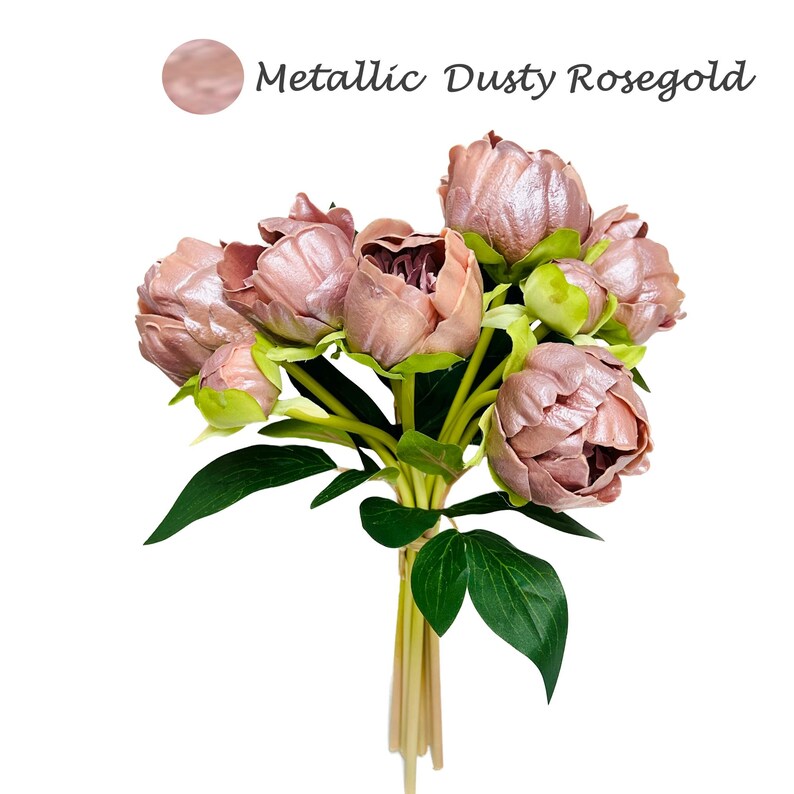 May include: A bouquet of dusty rosegold artificial peonies with green leaves. The peonies are arranged in a bunch and tied together with twine. The flowers are in various stages of bloom, with some fully open and others still in bud.