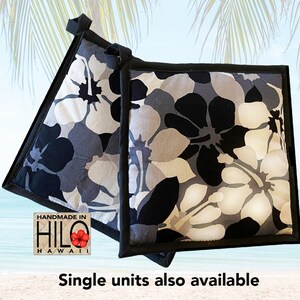 May include: Two black and white floral print pot holders with black trim. The pot holders are handmade in Hilo, Hawaii.