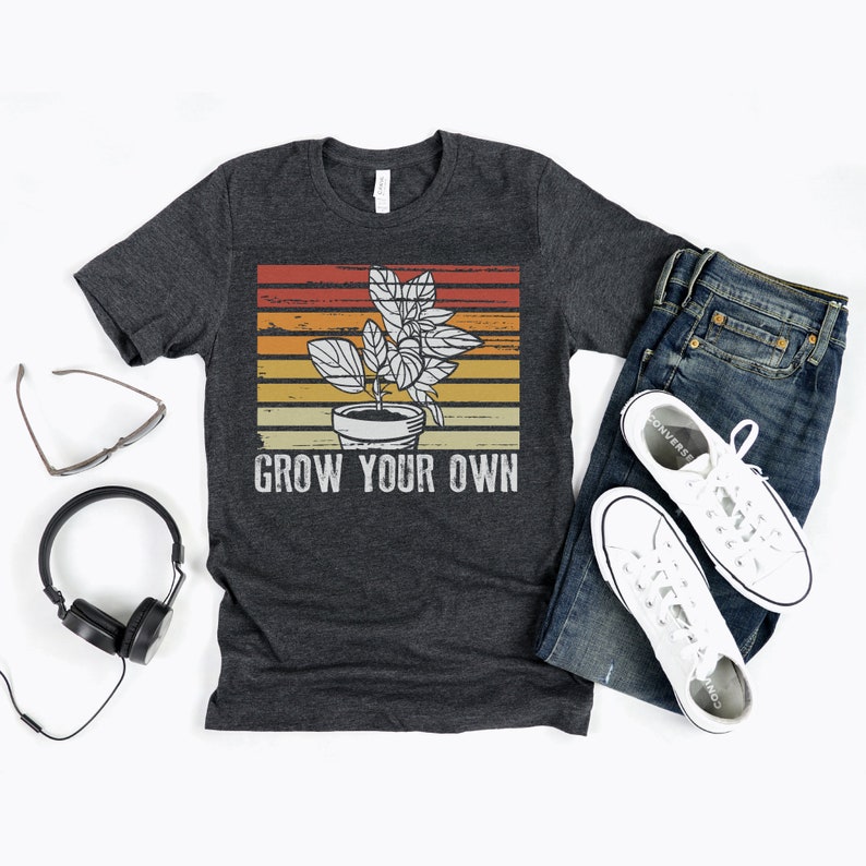 May include: A dark grey t-shirt with a vintage-style graphic of a potted plant and the text "Grow Your Own".