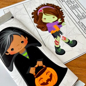 May include: A Halloween-themed chocolate bar wrapper featuring a cartoon witch with black hair and a black cape holding a jack-o'-lantern bucket. The wrapper also features a spiderweb pattern and the text "FN FACTS" with a list of percentages.