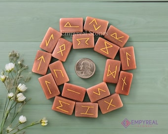 May include: Set of 16 pink and gold rune stones with gold runes on each stone. The stones are arranged in a circle on a green surface. The text "Empyreal Stones" is visible in the image.