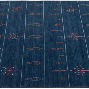 Evenly lit flat lay of minimalist tribal area rug, deep navy field with rust and mustard accents