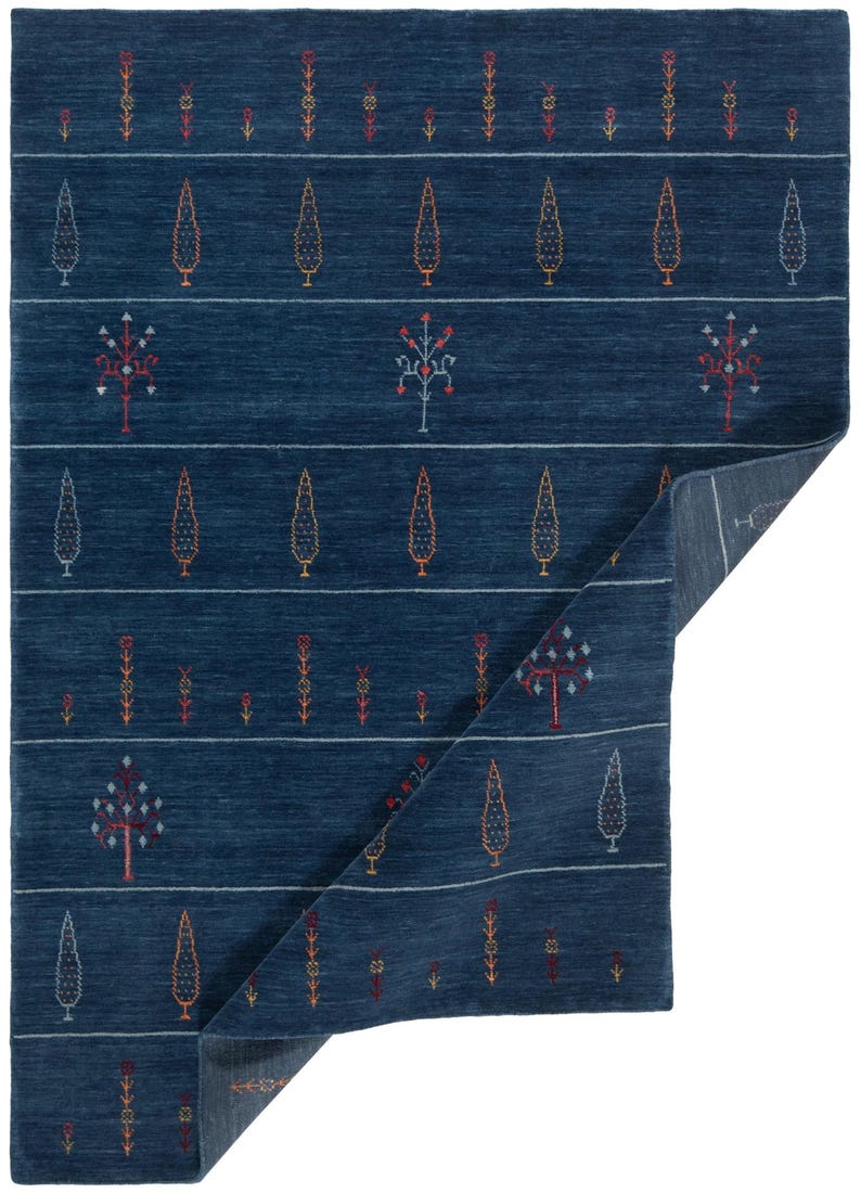Corner folded to show thin, structured drape and back, 8x10 handmade wool rug construction visible