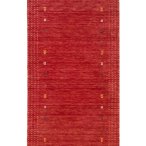 May include: A rectangular red rug with a textured surface. The rug has a border with small white stitches. The design includes small, repeating geometric shapes and stylized plant-like motifs in yellow, brown, and blue.