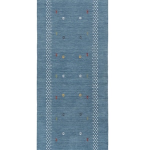 May include: A rectangular blue rug with a textured surface. The rug features a white dotted border and a central design of small squares and decorative elements in various colors. The rug is suitable for a hallway or entryway.