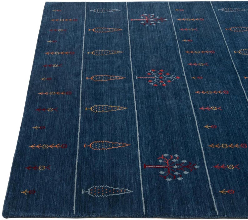 Close-up of linear striping and small geometric motifs, navy handwoven gabbeh carpet texture and edge detail