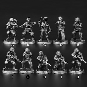 May include: Ten silver-coloured miniature soldier figurines in different poses. Each figure is on a circular base and wears military gear, including helmets and tactical vests. The collection includes soldiers holding weapons and in various combat stances. The figurines are labelled A to J.