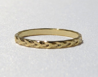 May include: A simple gold band ring with a textured, braided design.