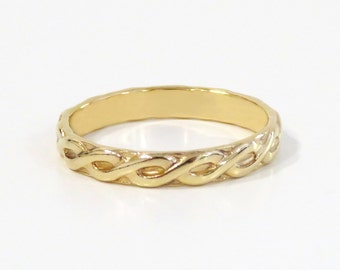 May include: A gold band ring with a braided design.