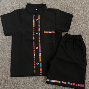 May include: Black short-sleeved button-up shirt with colorful trim and matching black shorts with colorful trim.