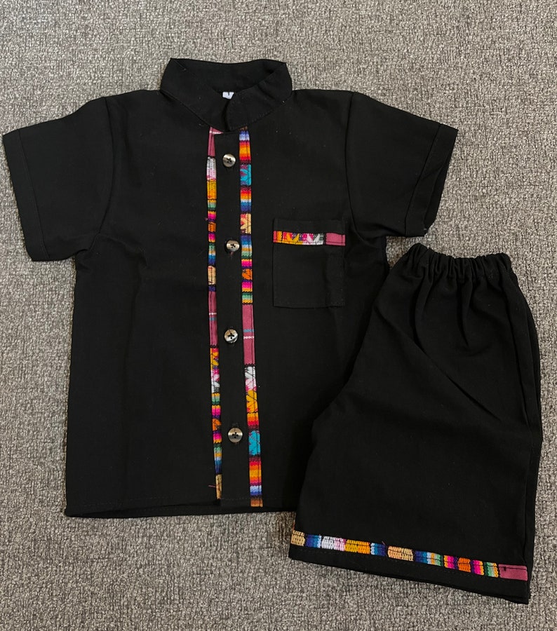 May include: Black short-sleeved button-up shirt with colorful trim and matching black shorts with colorful trim.