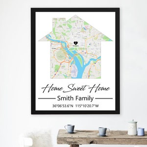 May include: Framed map art in a house shape, featuring a city map with a heart-shaped marker. The text reads "Home Sweet Home" and "Smith Family", with coordinates. The frame is black.
