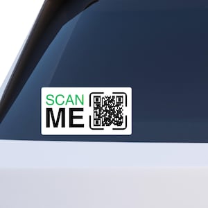 Peut inclure: Autocollant rectangulaire blanc avec les mots "SCAN ME" en noir et vert, à côté d'un code QR noir. L'autocollant est apposé sur une vitre de voiture.