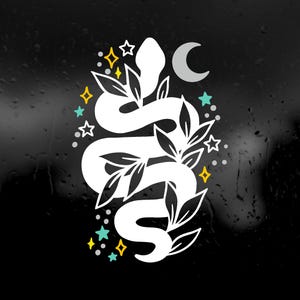 May include: A white vinyl decal featuring a coiled snake intertwined with black-outlined leaves. The design is accented by a grey crescent moon, yellow four-pointed stars, and small teal stars, all set against a dark, rain-streaked background.