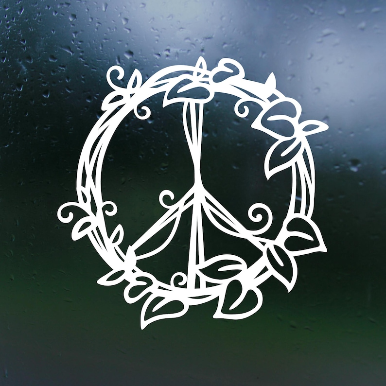 May include: A white peace sign surrounded by a wreath of leaves and flowers. The peace sign is a symbol of peace and love.