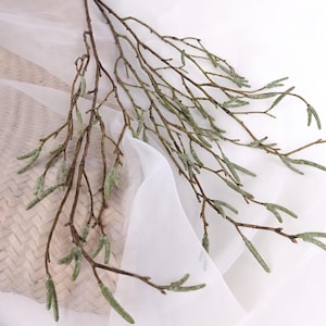 May include: Artificial birch branch featuring thin brown stems and small green catkins. This faux branch is designed for decorative purposes, suitable for floral arrangements or interior design, bringing a natural element indoors. The branch is a neutral colour.