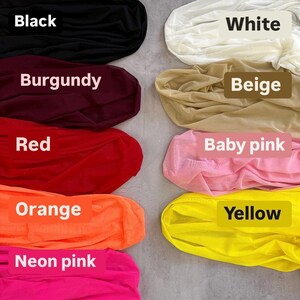 a bunch of different colors of clothing on a floor