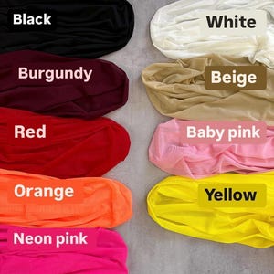 a bunch of different colors of clothing on a floor