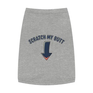 Puede incluir: Camiseta gris para perro con el texto "SCRATCH MY BUTT" en letras azules. Una flecha azul con punta roja apunta hacia abajo. La camiseta está hecha de un material suave y cómodo.
