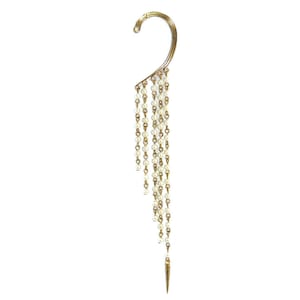 May include: Gold-toned ear cuff with a curved upper section and a cascade of small, white pearls. The pearls are strung together and end with a gold-colored, pointed charm. The ear cuff is designed to be worn on the ear.