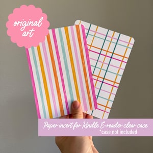 May include: Two paper inserts for a Kindle e-reader clear case. One insert has vertical stripes in pink, orange, yellow, and teal. The other has a plaid pattern in pink, teal, orange, and navy. The text "original art" is in a pink scalloped shape.