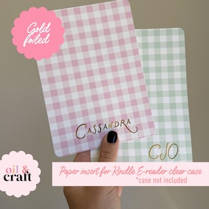 May include: Two rectangular paper inserts for Kindle e-reader clear cases. One is pink and white gingham, gold foiled with the name "Cassandra". The other is green and white gingham with the initials "CJO".