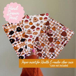 May include: Three rectangular paper inserts for a Kindle e-reader clear case, featuring a repeating pattern of autumn-themed icons like pumpkins, sweaters, mushrooms, and apples on a light brown and white gingham background with small stars.