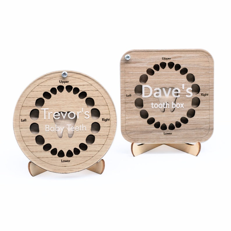 May include: Two wooden baby tooth boxes, one round and one square, with slots for each tooth. The round box says "Trevor's Baby Teeth" and the square box says "Dave's tooth box".