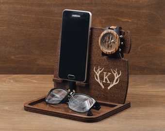 May include: Wooden phone stand with a watch holder, glasses tray, and a personalized initial "K" with antlers. The stand is made of dark brown wood.