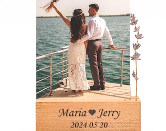 May include: A wooden block with the names "Maria" and "Jerry" engraved, along with the date "2024 05 20". The block features a photo of a couple on a boat, celebrating their wedding day. The bride is wearing a white lace dress.