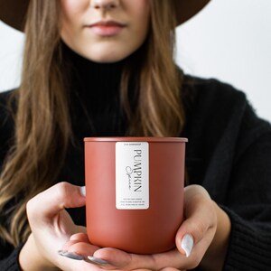 Puede incluir: Una vela marr&oacute;n con una etiqueta blanca que dice "Pumpkin Spice".