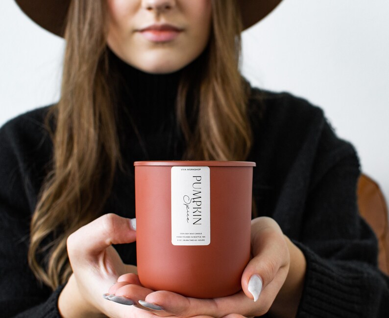 Puede incluir: Una vela marr&oacute;n con una etiqueta blanca que dice "Pumpkin Spice".