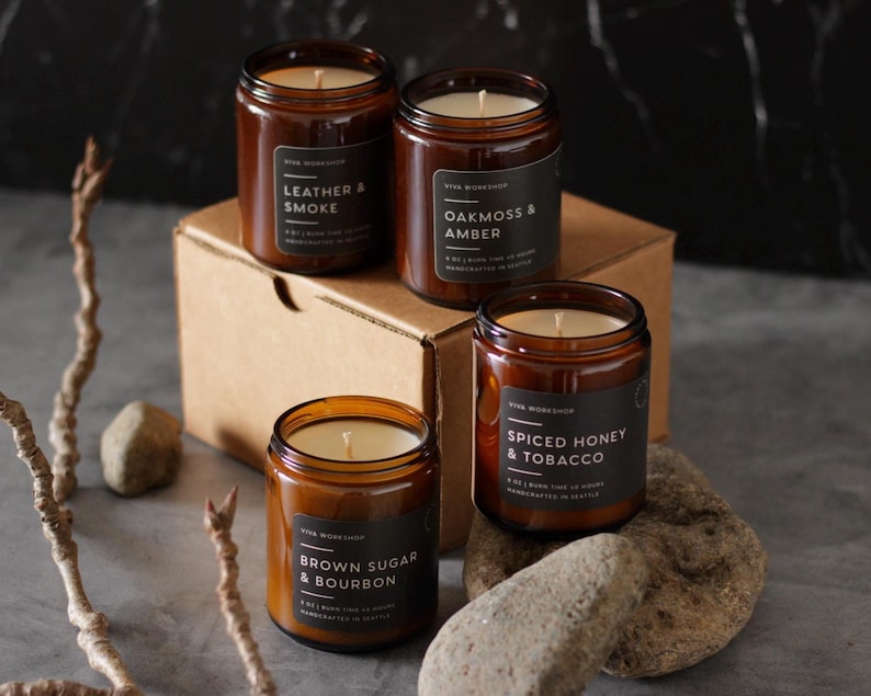 Puede incluir: Cuatro velas en frasco de vidrio &aacute;mbar con etiquetas negras. Las etiquetas dicen Leather & Smoke, Oakmoss & Amber, Spiced Honey & Tobacco y Brown Sugar & Bourbon. Cada vela de 8 oz tiene una mecha de algod&oacute;n centrada en cera blanca.