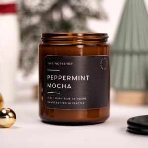 May include: A brown glass candle jar with a black label that reads "Viva Workshop Peppermint Mocha 8 oz | Burn Time 40 Hours Handcrafted in Seattle".