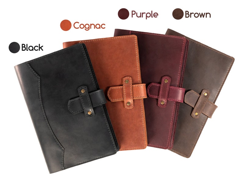 Peut inclure: Plusieurs carnets en cuir noir, cognac, violet et marron. Chaque carnet est dot&eacute; d'une fermeture &agrave; rabat avec une sangle et des ferrures couleur laiton. L'image comprend des &eacute;tiquettes de couleur : Noir, Cognac, Violet et Marron.