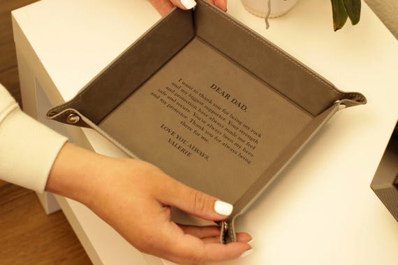 A real leather catchall tray, laser-engraved with a custom monogram — the kind of 'grown-up desk essential' that feels genuinely considered rather than grabbed off a shelf.