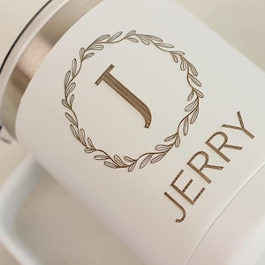 Puede incluir: Una taza de cer&aacute;mica blanca con un asa negra y el texto "But First, Coffee" en negrita negra. La taza est&aacute; sobre una superficie blanca. La taza mide 10 cm de alto.